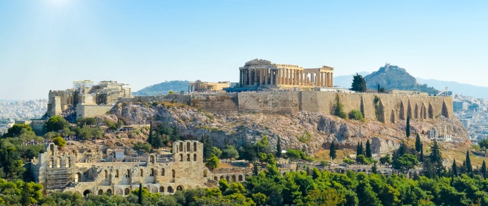 Acrópolis de Atenas en Grecia con el Partenón y restos arqueológicos rodeados de árboles y colinas