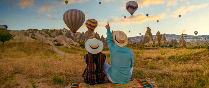 Dos personas observan globos aerostáticos en Capadocia al atardecer